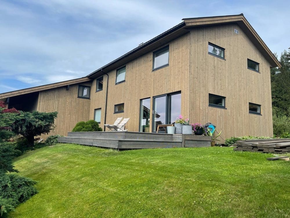 Rehabilitert enebolig i Fiskvikvegen 39, Skatval – ny trekledning, terrasse og velstelt hage, utført av Skotnes Bygg AS– rehabilitert enebolig sett fra siden, ny stende trekledning, utført av Skotnes Bygg AS