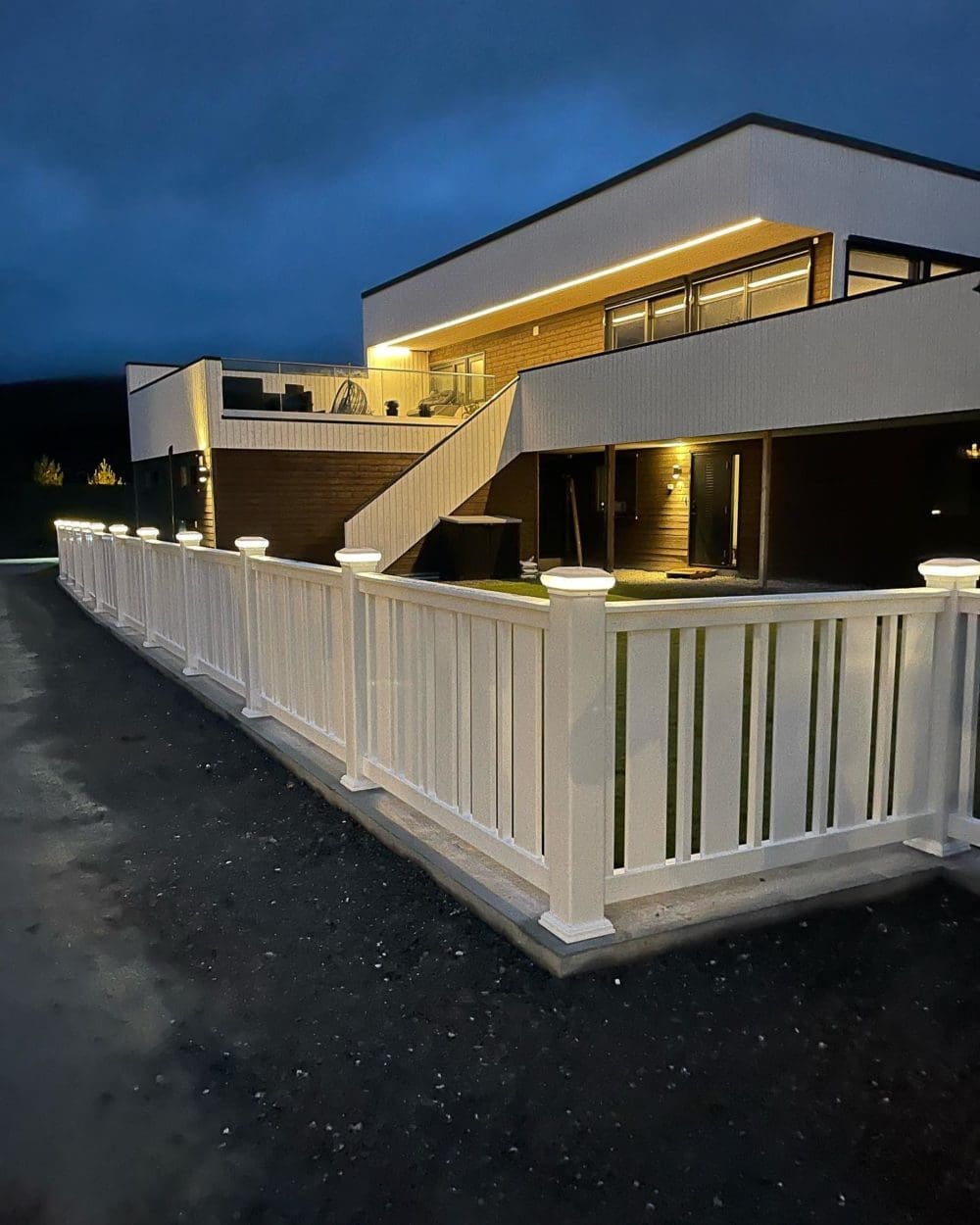 Kveldsbilde av enebolig med opplyst utendørs trappeoppgang og veranda – Gammelverksgata, Stjørdal, utført av Skotnes Bygg AS