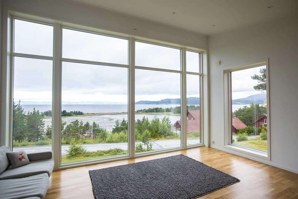 Innvendig stue med store panoramavinduer og fjordutsikt – enebolig i Furuvegen, Muruvik, utført av Skotnes Bygg AS