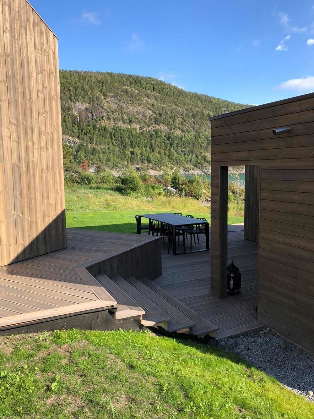 Hytte med anneks – romslig terrasse med utomøbler og mørk trekledning, utført av Skotnes Bygg AS